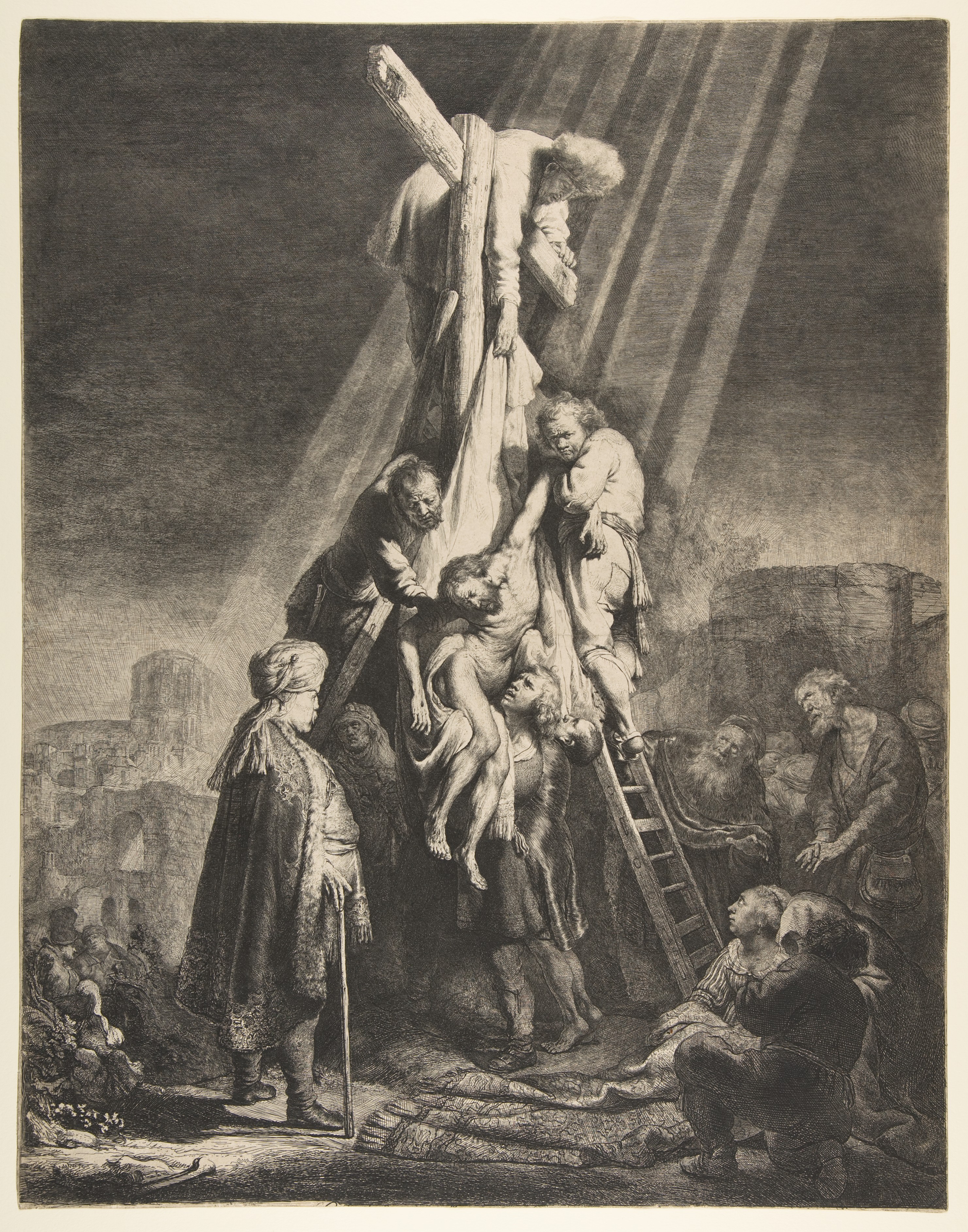 Estampa de Rembrandt con el descenso del cuerpo de Cristo y un grupo de figuras iluminadas junto a la cruz.